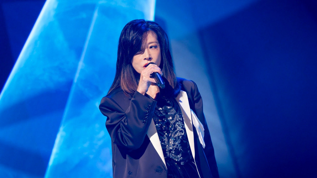 中森明菜在蓝色舞台灯光下献唱，NHK特辑横版封面